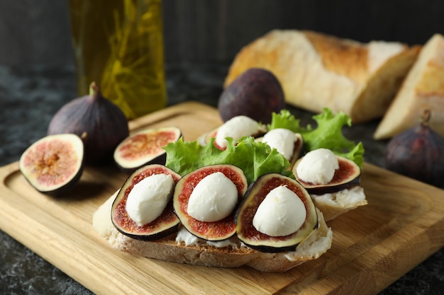 Concept de nourriture savoureuse avec bruschetta à la figue sur table smokey noire