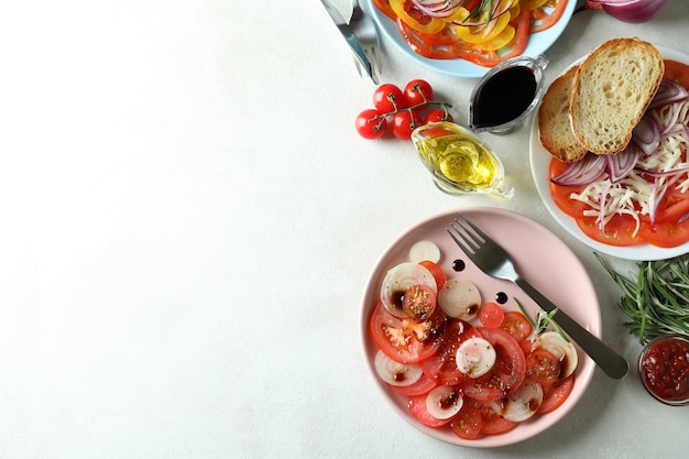 Concept de nourriture savoureuse avec carpaccio de tomates sur une table texturée blanche