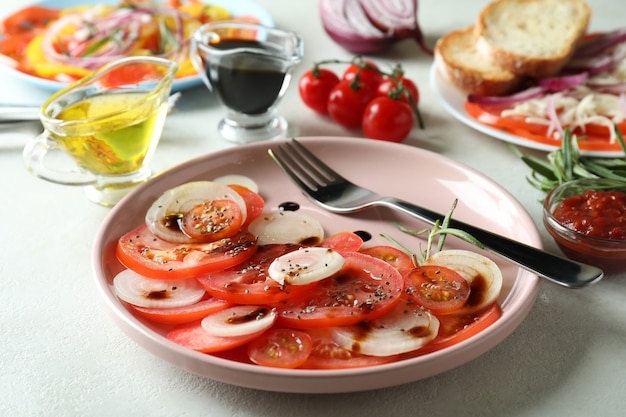 Photo concept de nourriture savoureuse avec carpaccio de tomates sur une table texturée blanche