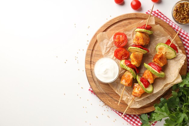 Concept de nourriture savoureuse avec du poulet shashlik sur fond blanc