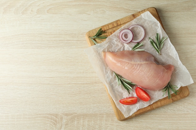 Concept de nourriture savoureuse avec filet de poulet cru sur fond en bois.