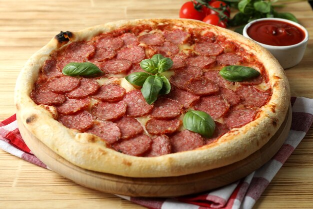 Concept de nourriture savoureuse avec pizza Salami sur fond de bois