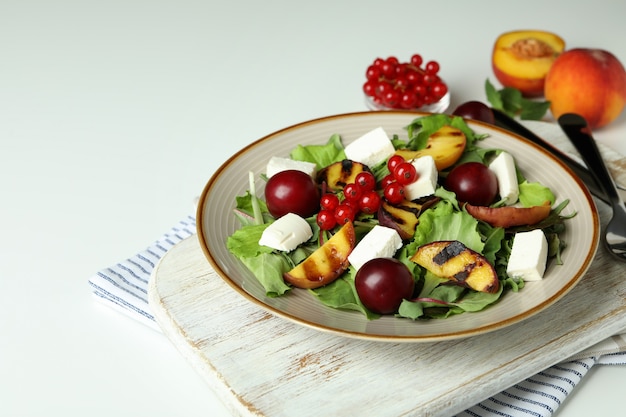 Concept de nourriture savoureuse avec salade aux pêches grillées sur fond blanc