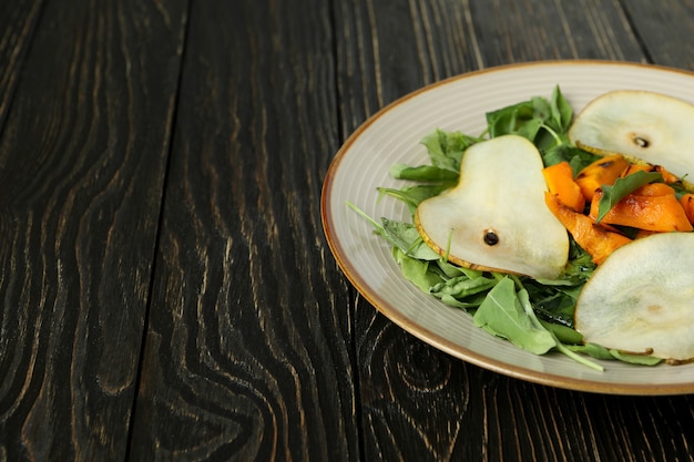 Concept de nourriture savoureuse avec salade de citrouille sur fond de bois