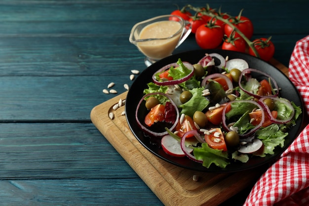 Concept de nourriture savoureuse avec salade de légumes à la sauce tahini sur fond de bois