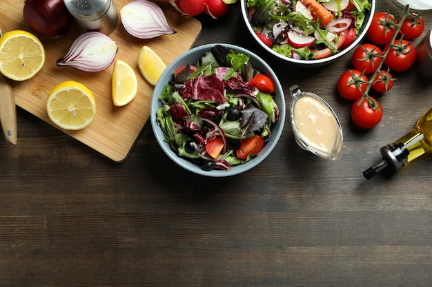 Concept de nourriture savoureuse avec salade de légumes à la sauce tahini sur fond de bois