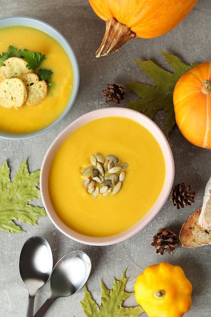 Photo concept de nourriture savoureuse avec soupe de citrouille sur une table texturée grise