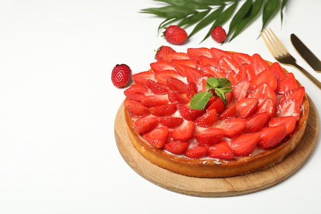 Concept de nourriture savoureuse avec tarte aux fraises sur fond blanc.