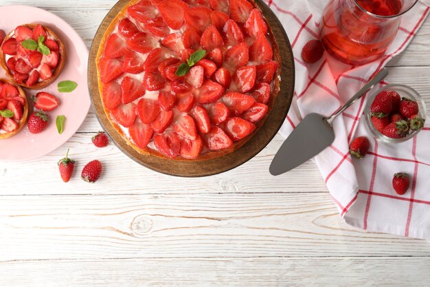 Concept de nourriture savoureuse avec tarte aux fraises sur fond de bois blanc.