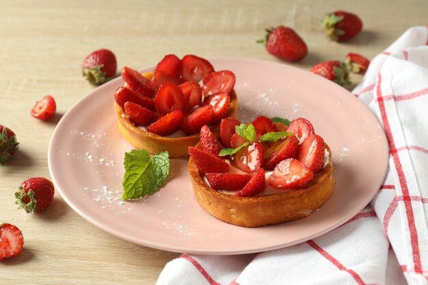 Concept de nourriture savoureuse avec tarte aux fraises sur table en bois.