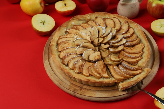 Concept de nourriture savoureuse avec tarte aux pommes sur fond rouge