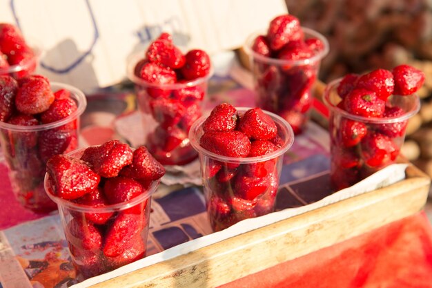 concept de nourriture, de vente et de restauration - fraise dans des gobelets en plastique au marché de rue