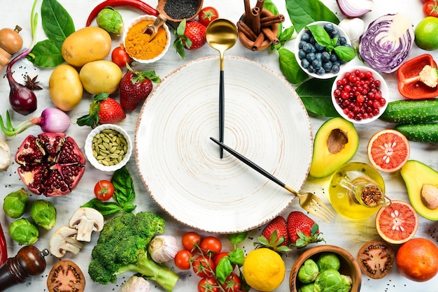 Le concept de nutrition diététique fruits et légumes frais Couverts et assiette en forme d'horloge Vue de dessus Espace libre pour votre texte