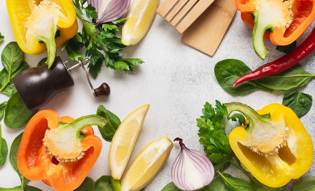 Concept de nutrition saine et de cuisine diététique. Ingrédients frais pour manger des légumes, des épices, des herbes et de l'huile d'olive vieux mur de béton gris. Vue de dessus