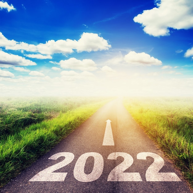 Concept d'objectifs du nouvel an 2022 : route asphaltée vide, soleil et ciel bleu avec texte aller à 2022