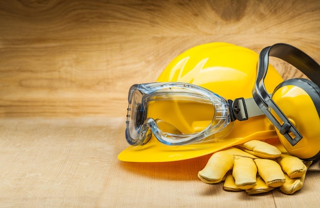 Concept d'outils de sécurité de construction de sécurité casque de construction jaune gants en cuir et écouteurs