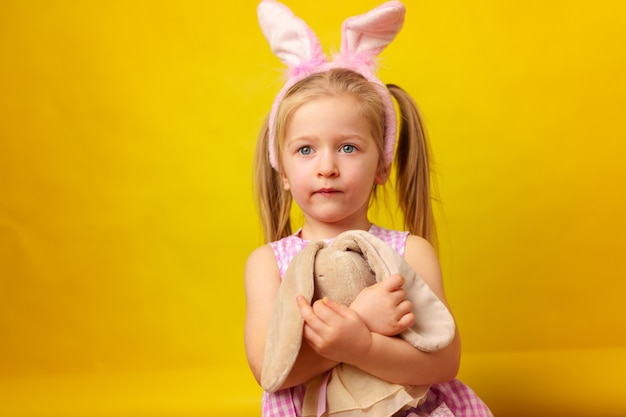 Concept de Pâques. Fille heureuse blonde enfant en bas âge avec des oreilles de lapin