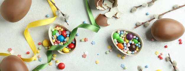 Concept de Pâques avec des oeufs en chocolat sur une surface texturée blanche