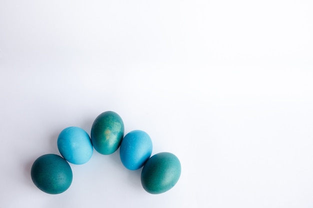 Concept de Pâques, vacances, tradition, style et minimalisme - Rangée d'oeufs de Pâques bleus ombre isolés sur fond blanc