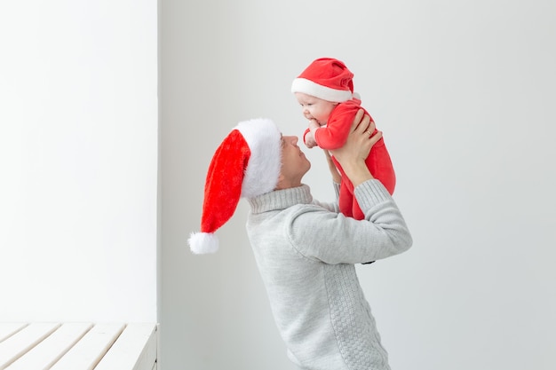 Concept de paternité et de vacances - Père avec son petit garçon portant des chapeaux de Père Noël pour célébrer Noël