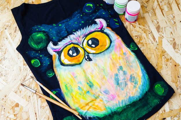 Concept De Peinture. Un Hibou Peint Sur Un T-shirt Noir.