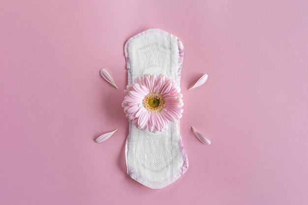 Concept de période de menstruation Coussin féminin blanc hygiénique avec des fleurs de gerbera Protection des menstruations Santé des femmes