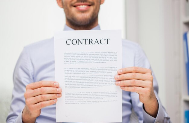 Photo concept de personnes, d'affaires et de paperasserie - gros plan d'un homme d'affaires souriant tenant un document contractuel