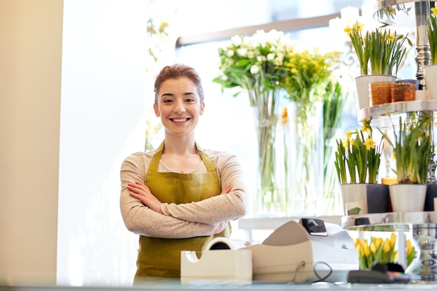 concept de personnes, d'affaires, de vente et de fleuristerie - femme fleuriste souriante et heureuse à la caisse du magasin de fleurs