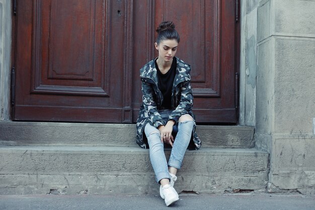 Concept de personnes, de beauté, de mode, de style de vie et de couleur - Portrait complet du corps en plein air d'une belle jeune fille souriante et heureuse posant dans la rue. Modèle regardant la caméra. Dame portant des vêtements élégants