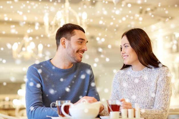 concept de personnes, de communication et de rencontres - couple heureux buvant du thé au café ou au restaurant