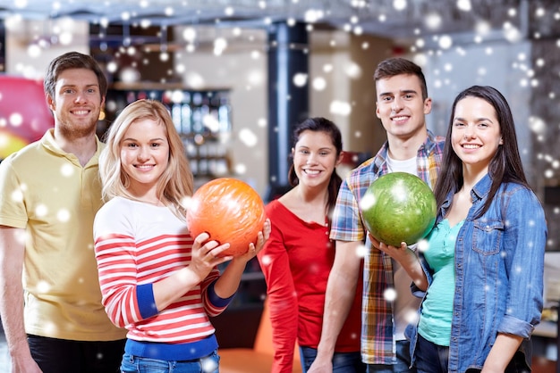 concept de personnes, de loisirs, de sport, d'amitié et de divertissement - amis heureux dans un club de bowling en hiver