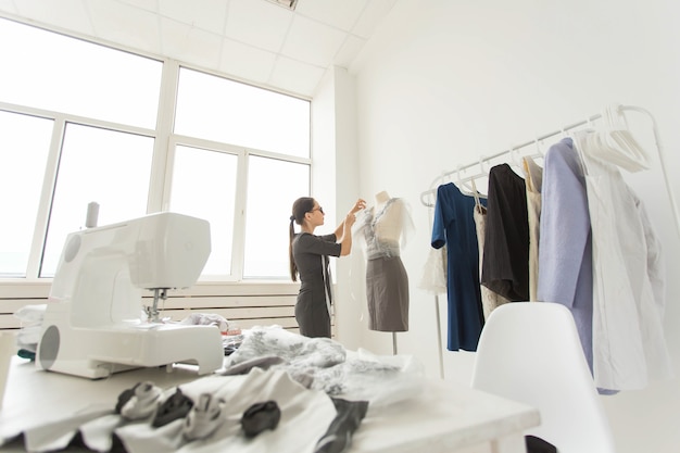 Concept de personnes, de mode et de salle d'exposition - jeune créatrice de mode dans sa salle d'exposition.