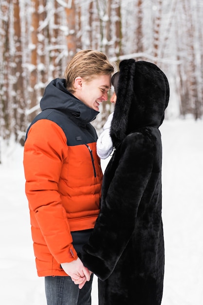 Concept de personnes, de saison, d'amour et de loisirs - couple heureux à l'extérieur en hiver.