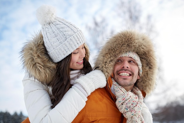 concept de personnes, de saison, d'amour et de loisirs - couple heureux s'amusant sur fond d'hiver