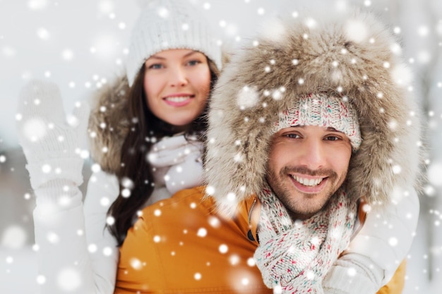 concept de personnes, de saison, d'amour et de loisirs - couple heureux s'amusant sur fond d'hiver