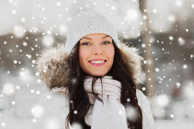 concept de personnes, de saison et de loisirs - femme heureuse à l'extérieur en vêtements d'hiver