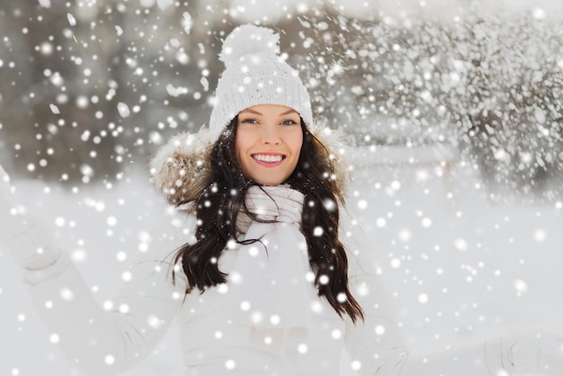 concept de personnes, de saison et de loisirs - femme heureuse avec de la neige à l'extérieur en hiver