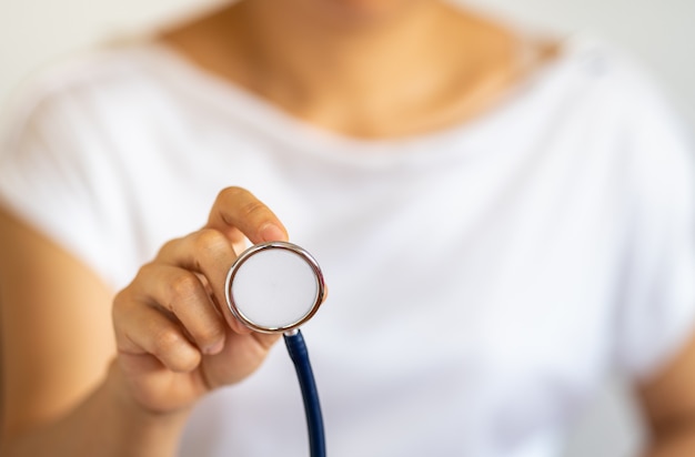 Concept de personnes et de soins de santé. Gros plan de la main de la femme tenant le stéthoscope du médecin.