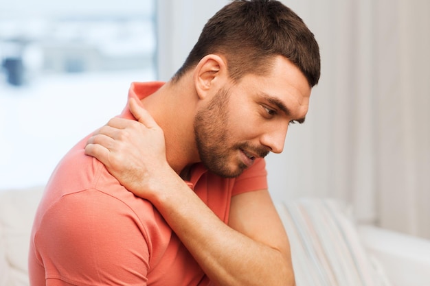 concept de personnes, de soins de santé et de problèmes - homme malheureux souffrant de douleurs au cou à la maison