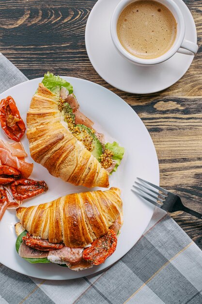 Le concept d'un petit-déjeuner copieux et savoureux de croissants frais classiques avec une variété de garnitures de ricotta jamon avocat fraises tomates séchées et moutarde française