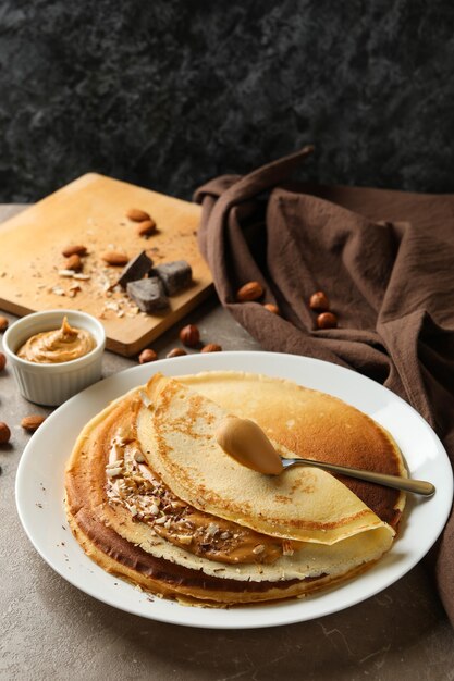 Concept de petit-déjeuner avec crêpes au beurre d'arachide et noix sur tableau gris