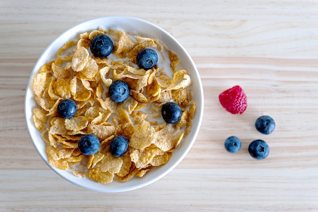 Concept de petit-déjeuner sain avec café yogourt fruits rouges et croissant sur table en bois