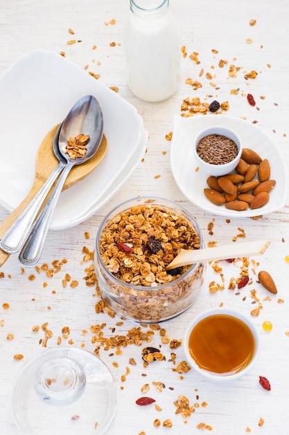 Concept de petit-déjeuner sain avec muesli omemade, miel, noix et lait