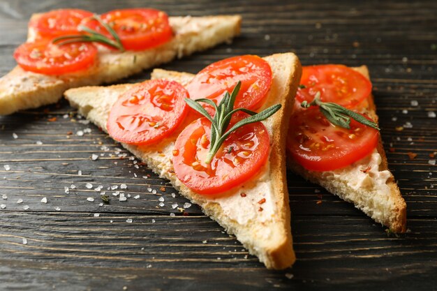 Concept de petit-déjeuner avec des toasts à la tomate sur fond de bois