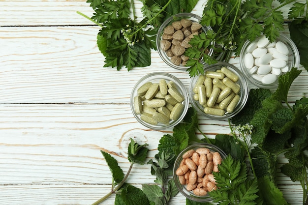 Concept de pilules de phytothérapie sur table en bois blanc, espace pour le texte