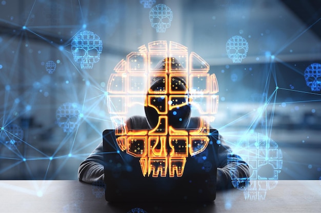 Concept de piratage et de sécurité Internet hacker en silhouette à capuche à l'aide d'un ordinateur portable et d'un symbole de crâne rougeoyant numérique double exposition