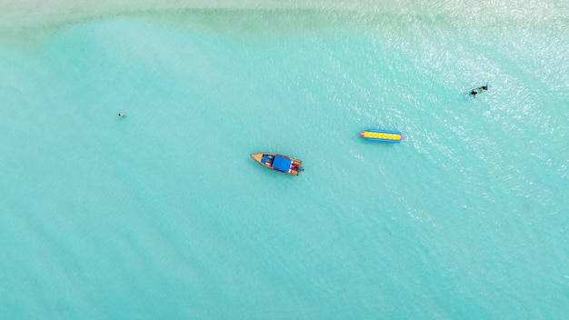 Photo concept de plage naturelle vacances d'été nature de la plage d'été tropicale parapluie à bord d'un bateau et d'un bateau sur la plage de sable et le tourisme heureux de jouer sur le sable