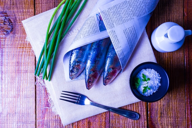 Concept de plat avec des sardines sur gros sel sur plaque noire