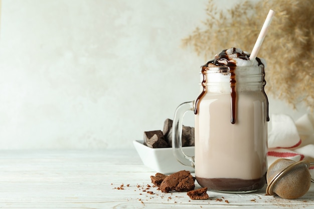 Concept de plats délicieux avec milk-shake au chocolat sur table en bois blanc