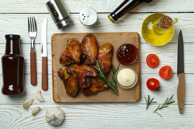 Concept de plats savoureux avec des ailes de poulet cuit au four sur bois blanc